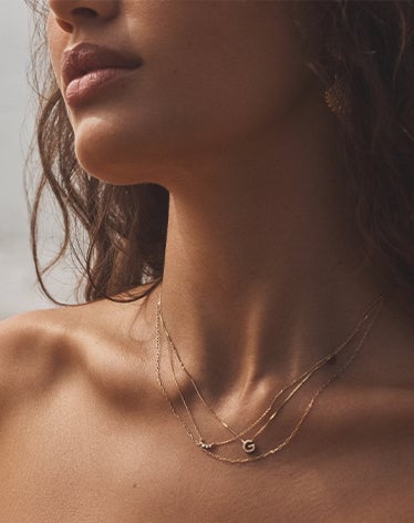 Woman wearing solid gold and diamond necklaces
